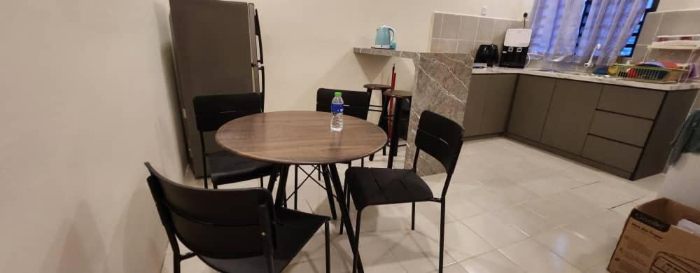 a kitchen with a table and chairs in a room at Hayyan Homestays in Kuantan