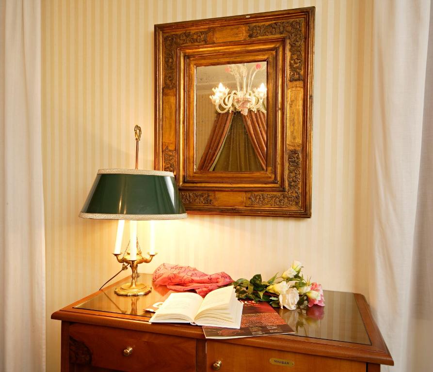 a table with a lamp and two books on it at Hotel Kette in Venice