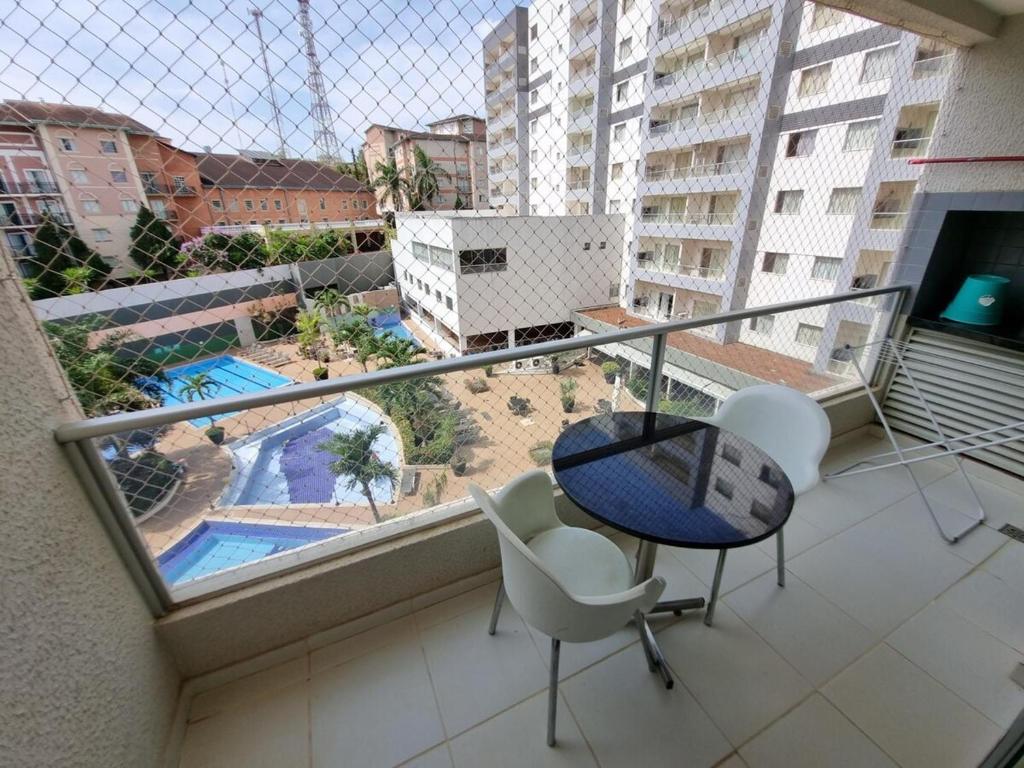 un balcone con tavolo, sedie e piscina di apto 323 Flat Veredas · Flat Hotel Veredas Rio Quente Hot Park a Rio Quente