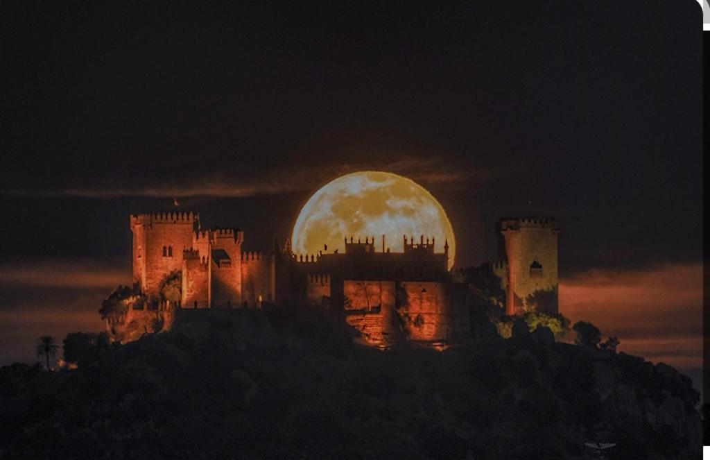 a castle with a full moon in the background at Góngora in Almodóvar del Río