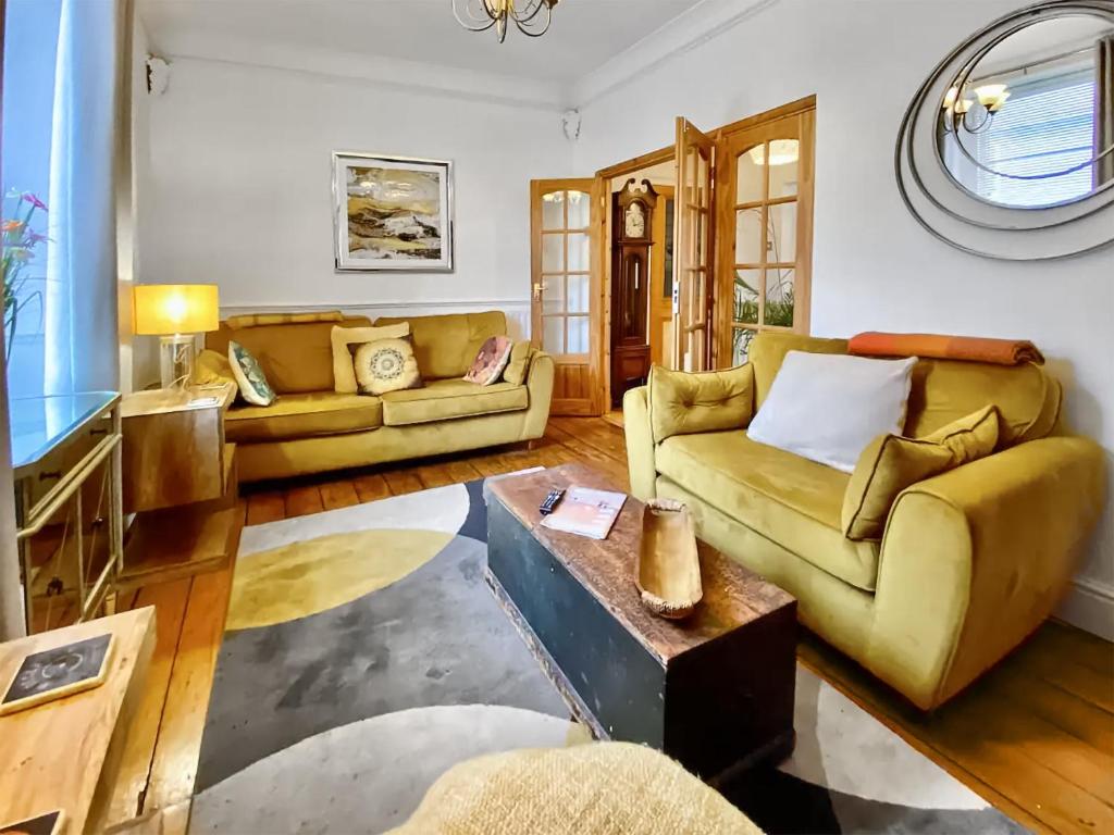 uma sala de estar com dois sofás e uma mesa em Four-tunes em Torquay