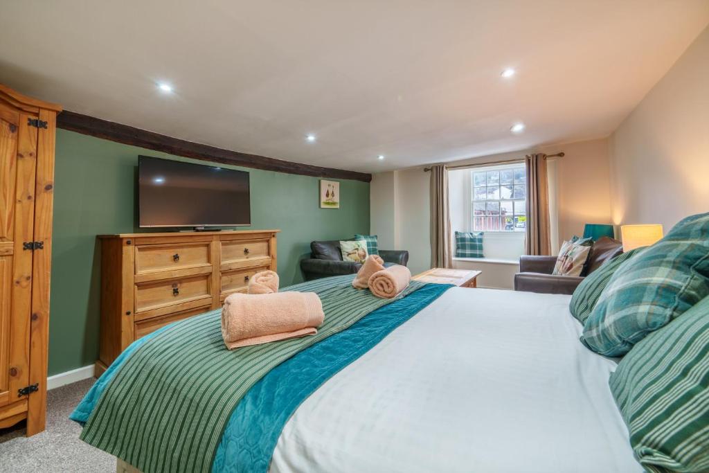 a bedroom with a large bed with a flat screen tv at Library View Apartment in Kendal