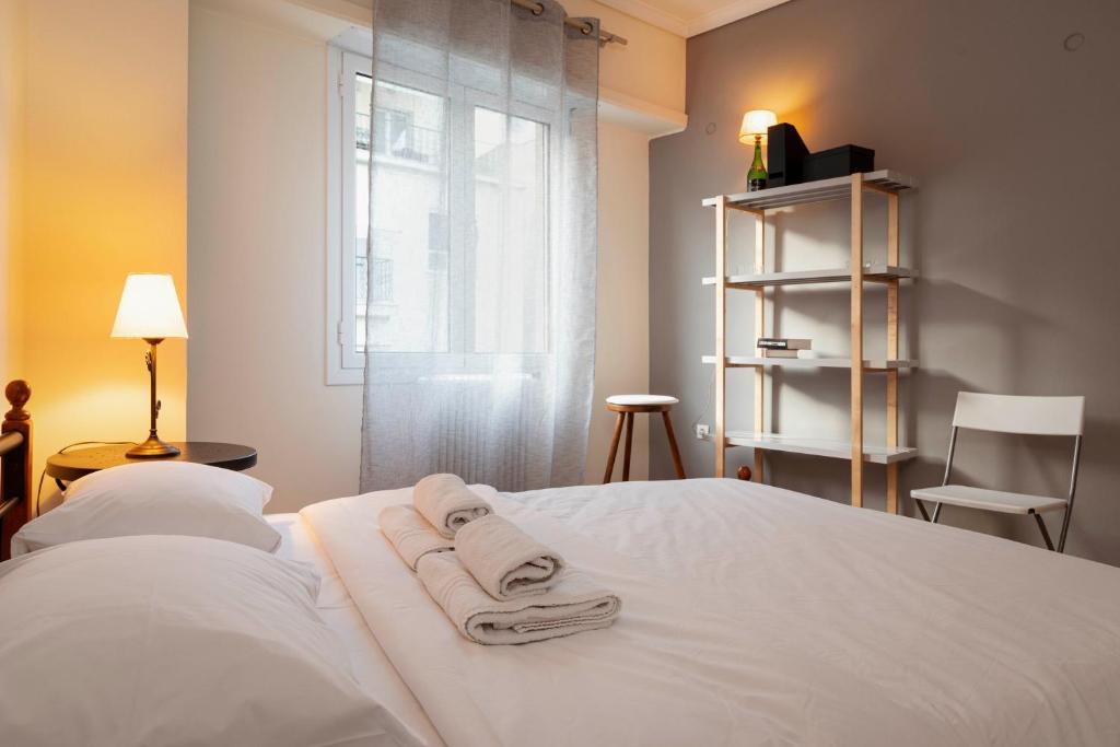 Un dormitorio con una cama blanca con toallas. en Charming 1Bd apartment in Athens en Atenas