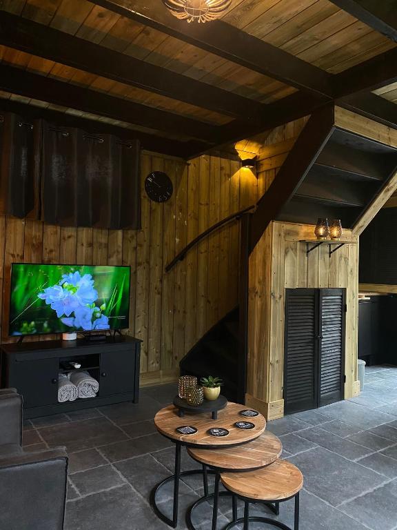 een woonkamer met een tv en een tafel bij gezellige cottage in zeeland in Sint Annaland