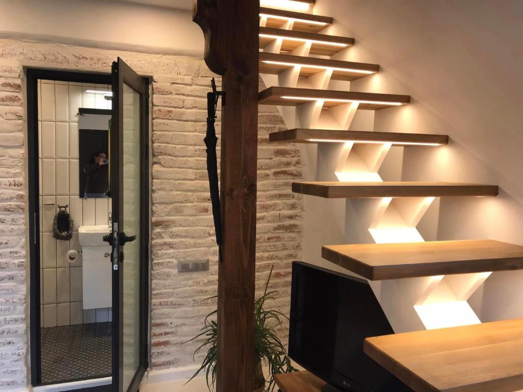 a staircase in a room with a television and a bathroom at LUXURY STUDIO in Veliko Tŭrnovo