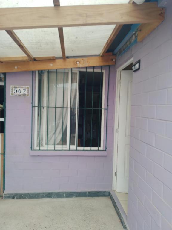 una puerta de garaje con una ventana en un edificio en Pieza individual con baño privado en sector Puertas del mar en La Serena
