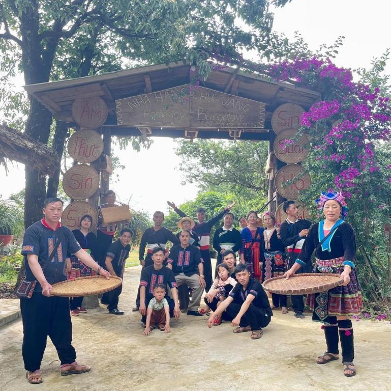 een groep mensen die poseren voor een foto onder een hek bij Homestay Chu Vang in Phong Thổ