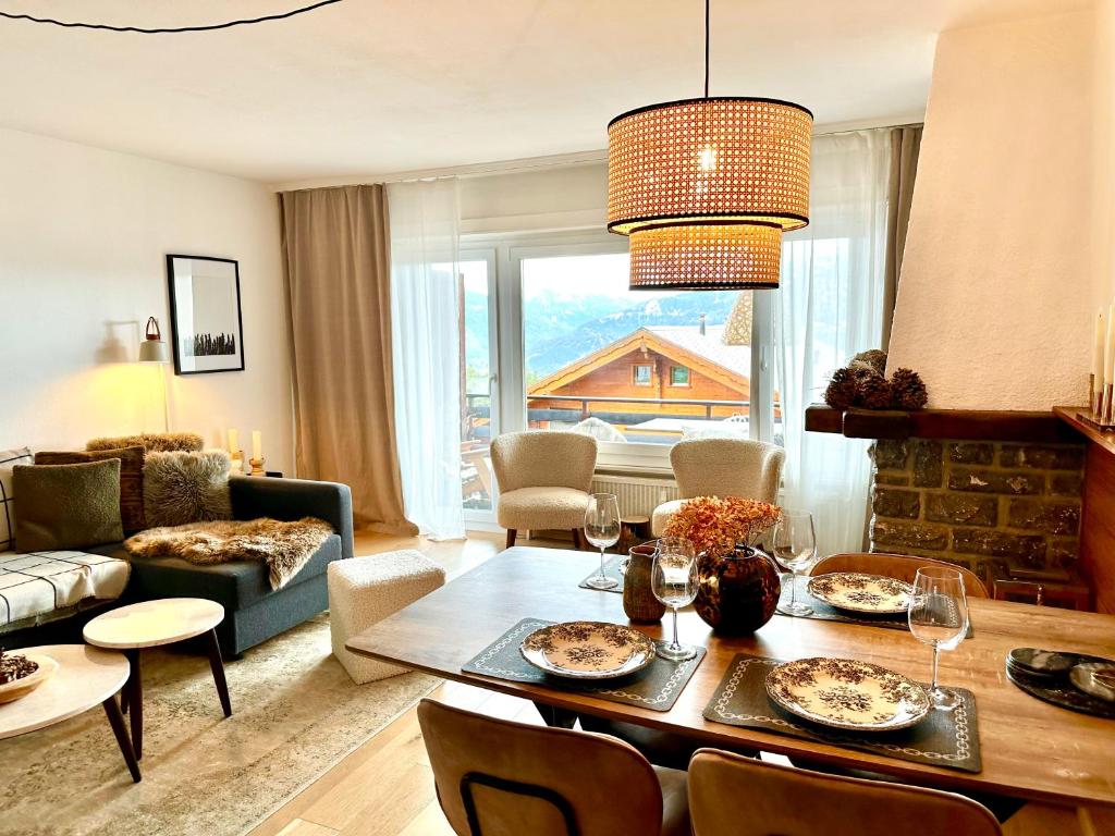 a living room with a table and a dining room at Window on Crans Montana, Appartement avec vue sur les Alpes in Crans-Montana