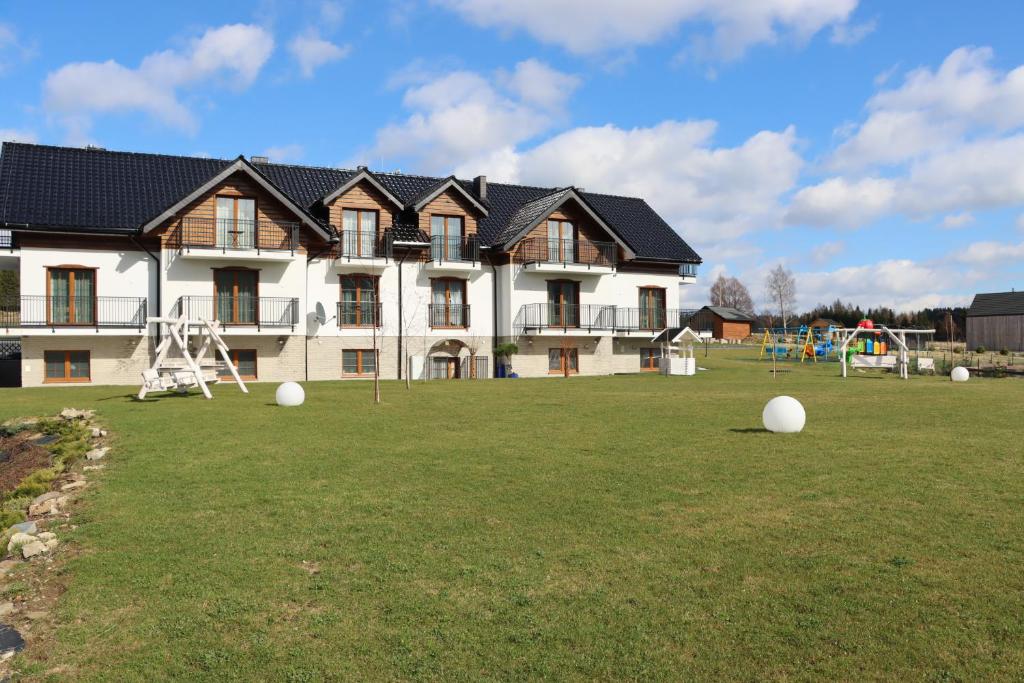 un grande edificio con parco giochi di fronte di Jagodowy Ski & Spa a Lasowka