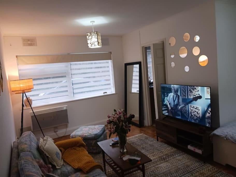 uma sala de estar com um sofá e uma televisão de ecrã plano em Stanmore em Stanmore