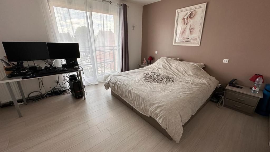Schlafzimmer mit einem Bett und einem Flachbild-TV in der Unterkunft 6 chambres idéales JO 2024 in Jouars-Pontchartrain