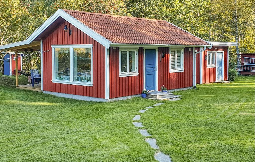 a small red house with a grass yard at Gorgeous Home In Strmstad With House Sea View in Strömstad