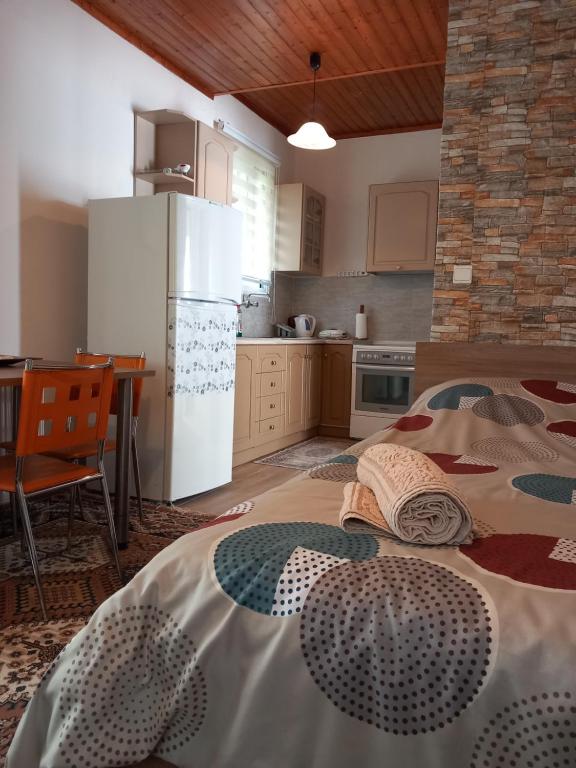 a kitchen with a bed and a table and a refrigerator at Casa Fare in Kalamata