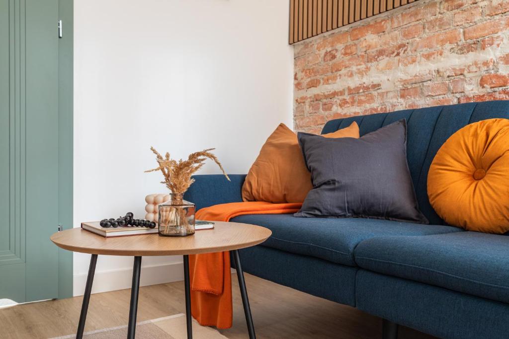 a living room with a blue couch and a table at SuperApart Orla 5 in Warsaw