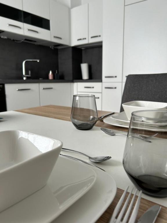 - Mesa de cocina con 2 vasos, platos y utensilios en Ferienwohnung Zur Wildkatze en Hallenberg