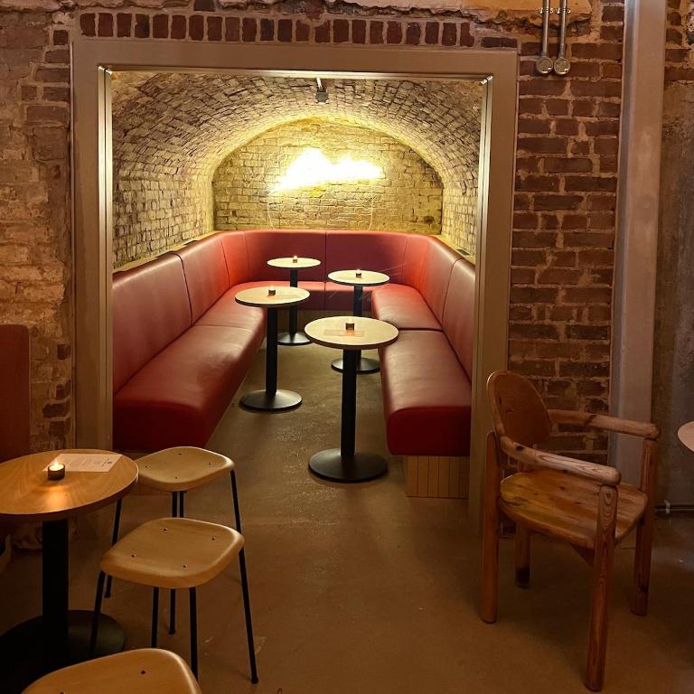 a restaurant with tables and a couch in a brick wall at Fort Road Hotel in Margate