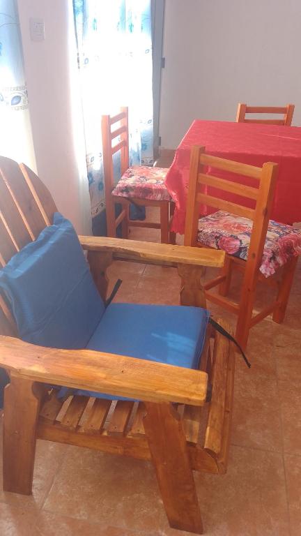 um quarto com três cadeiras de madeira e uma mesa em 24/7 em Centenario