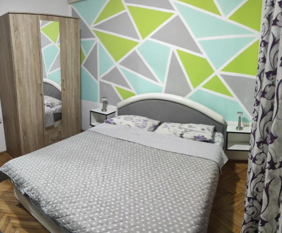 皮羅特的住宿－Apartman Ela，一间卧室设有一张床和几何墙