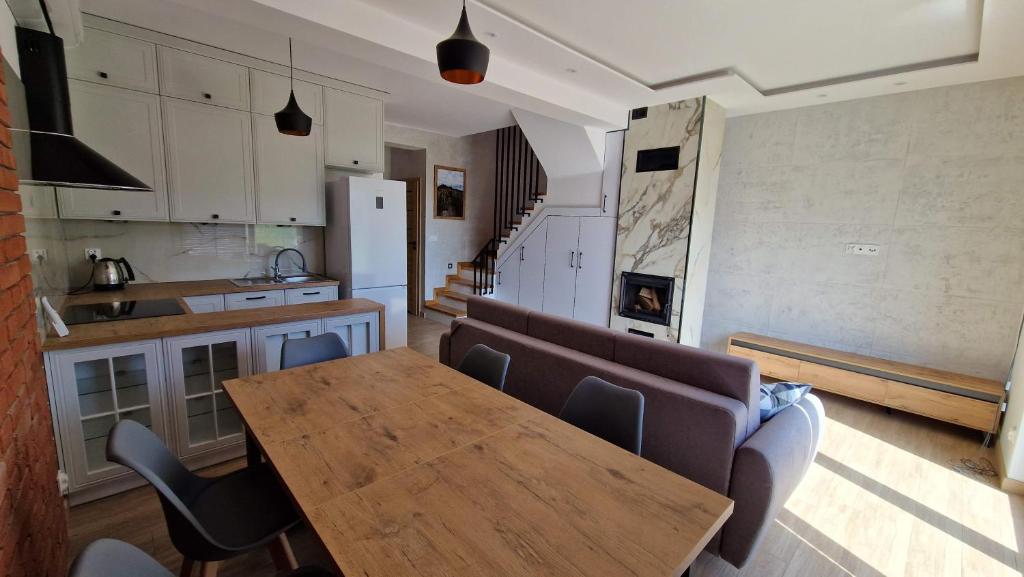 a kitchen with a wooden table and a couch at Letnia in Wilkasy