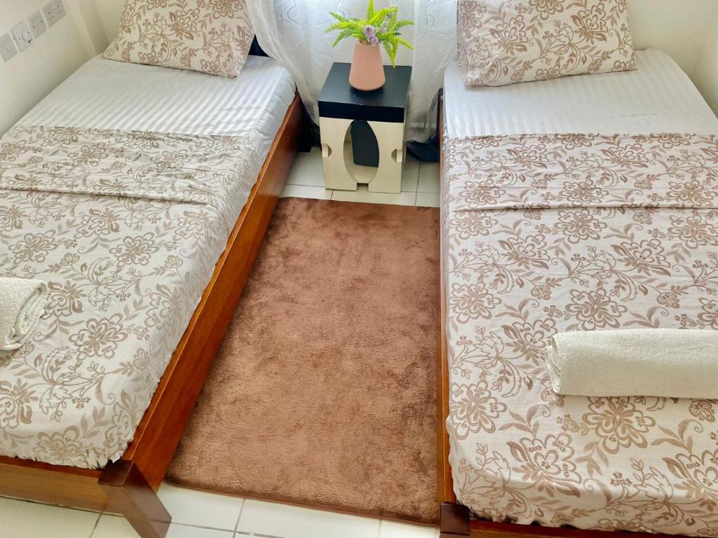 two beds sitting next to each other in a room at Ample home 2 bedroom apartment in Mombasa