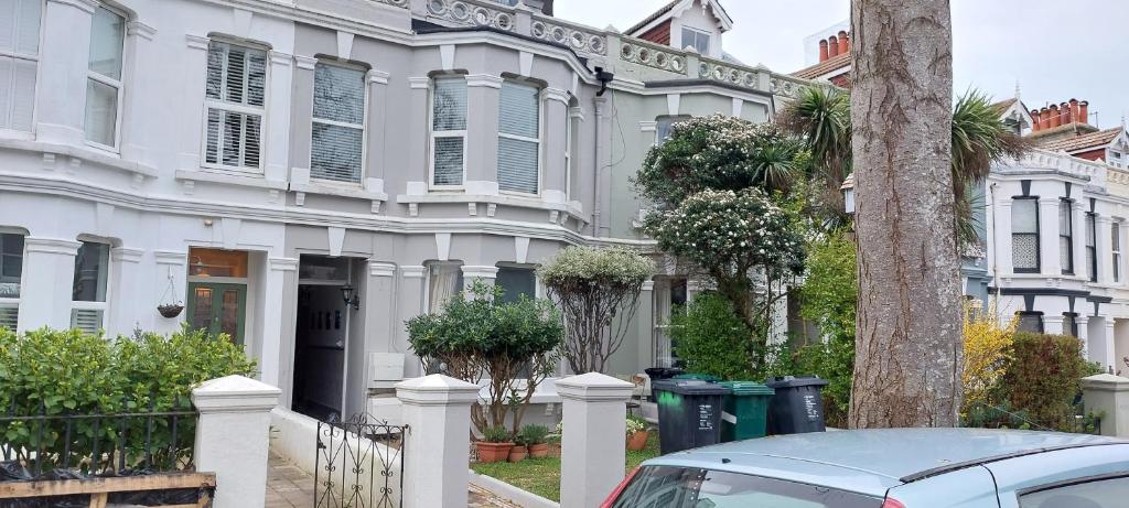 a white house with a car parked in front of it at Pebbles Place in Brighton & Hove