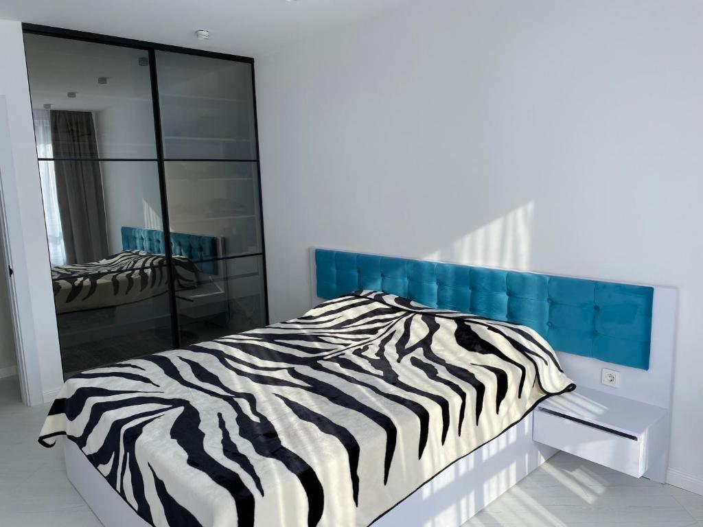 a zebra print bed in a white room with a mirror at Apartment 2 bedrooms in Chişinău