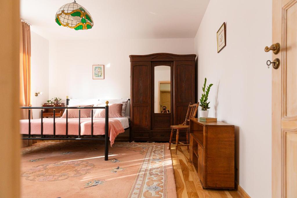 Pink Rose Suite في يوزيفوف: غرفة نوم بسرير وخزانة ومرآة