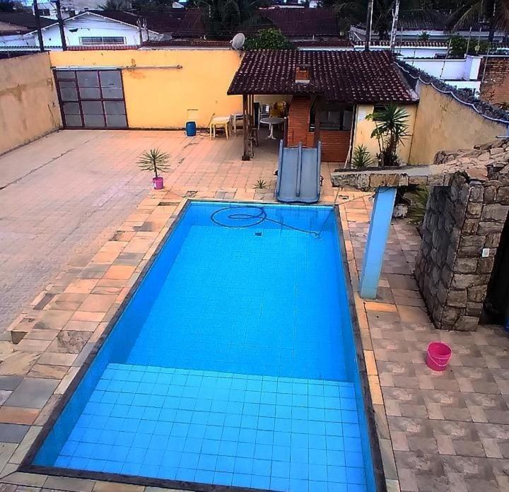 una gran piscina azul frente a una casa en casa do fred, en Guarujá