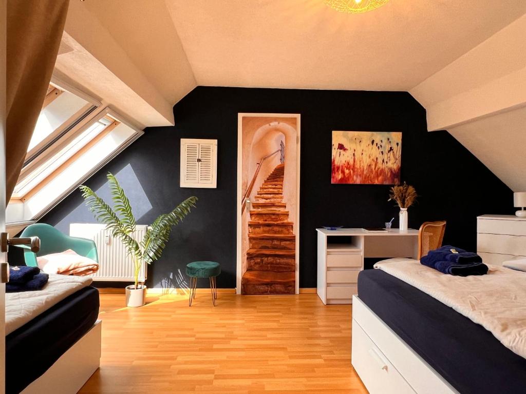 1 dormitorio con 2 camas y escritorio. en Ferienwohnung Aurora - WLAN, 2 Schlafzimmer, TV, Küche, Bad, Waschmaschine, en Malterdingen