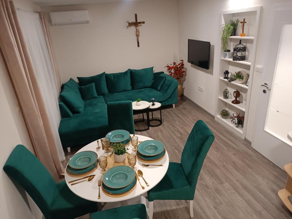 sala de estar con sofá verde y mesa en Apartment GORA, en Međugorje