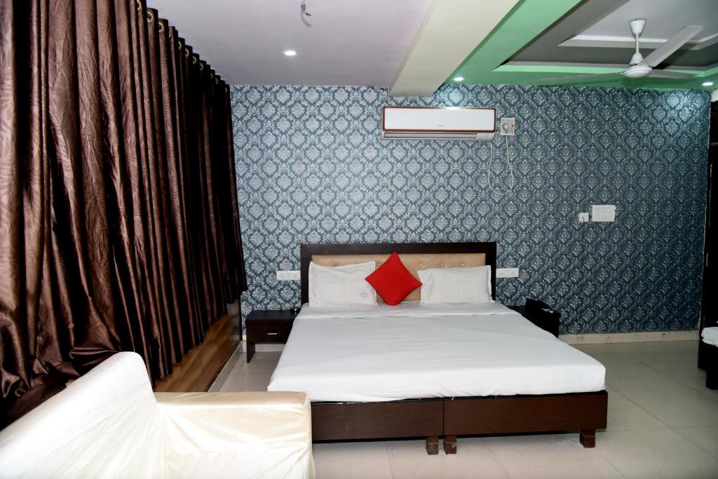 - une chambre avec un lit et des oreillers rouges dans l'établissement TRPOTEL SUBMANGAL, à Gwalior