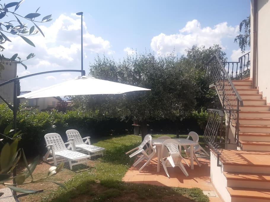 un patio con mesa, sillas y sombrilla en Appartamento Giglio Rosso, en Scarperia