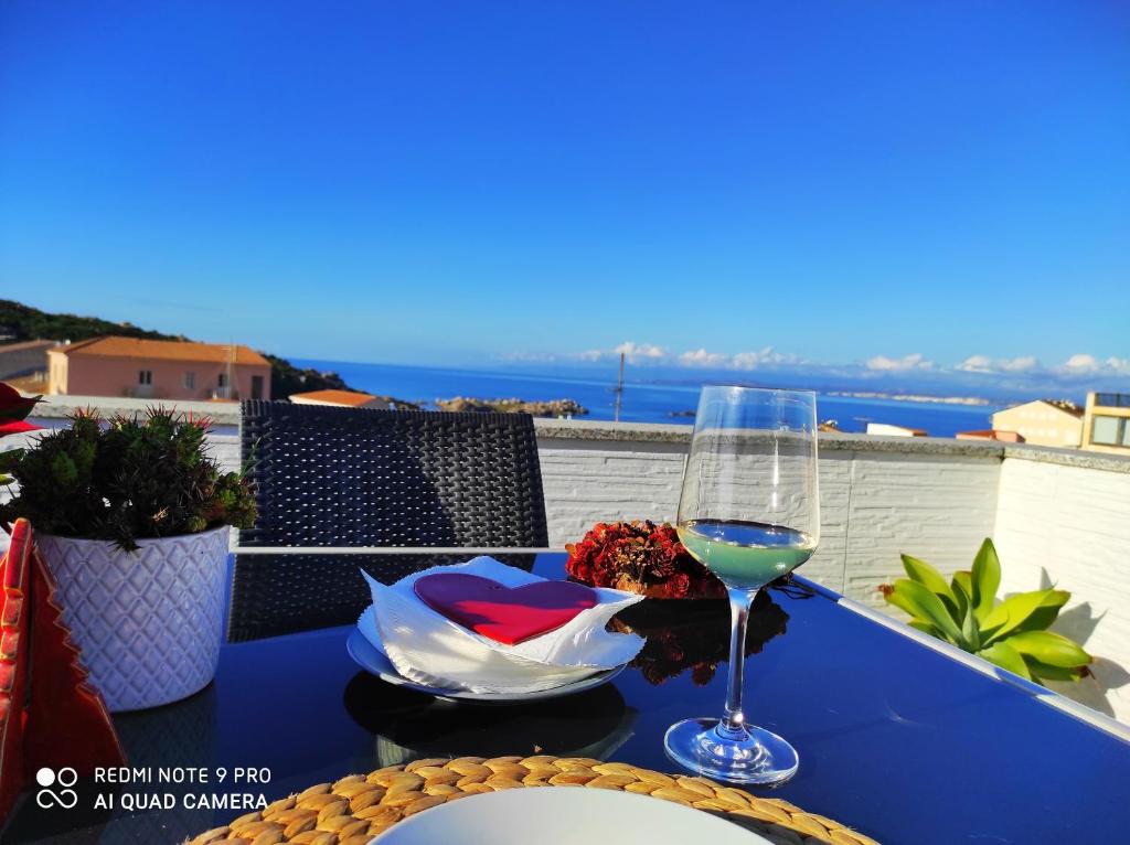 a blue table with a glass of wine on a balcony at B&B Domus de Janas Santa Teresa Gallura in Santa Teresa Gallura