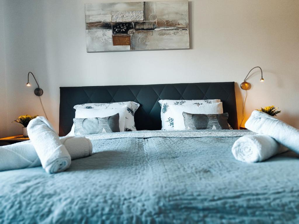 - une chambre avec un lit bleu et des oreillers blancs dans l'établissement Apartman Selska, à Zagreb