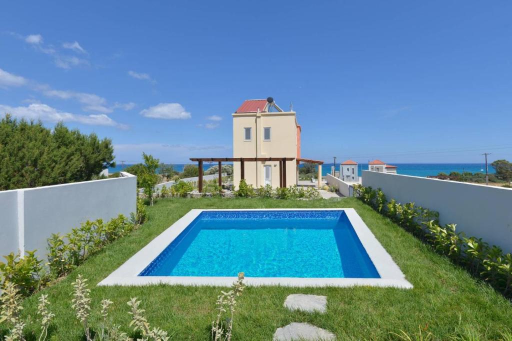 a villa with a swimming pool and a lighthouse at Verona Pool Villa in Lachania
