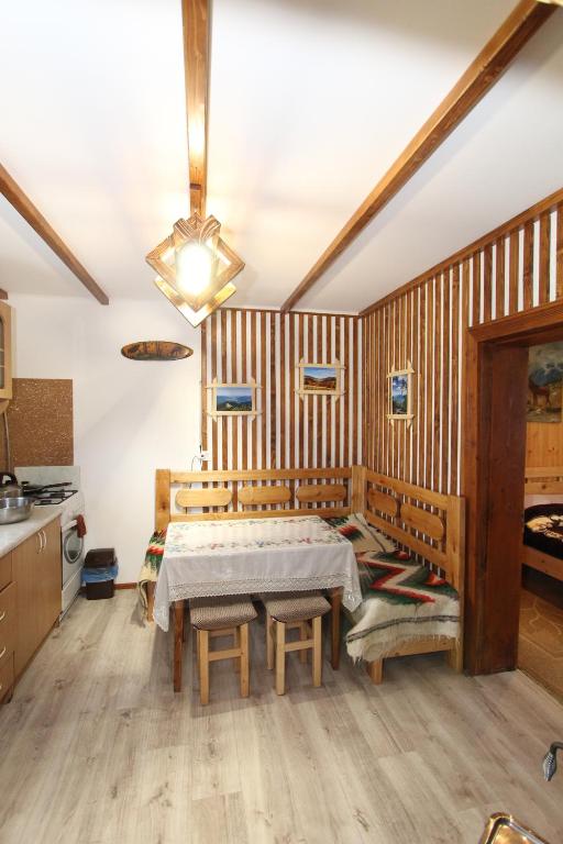 ein Esszimmer mit einem Tisch und einer Küche in der Unterkunft Будиночок для щастя in Jaremtsche