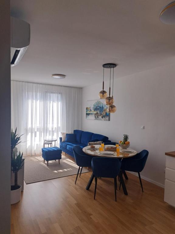 Una sala de estar con un sofá azul y una mesa. en Salona Lux, en Klis