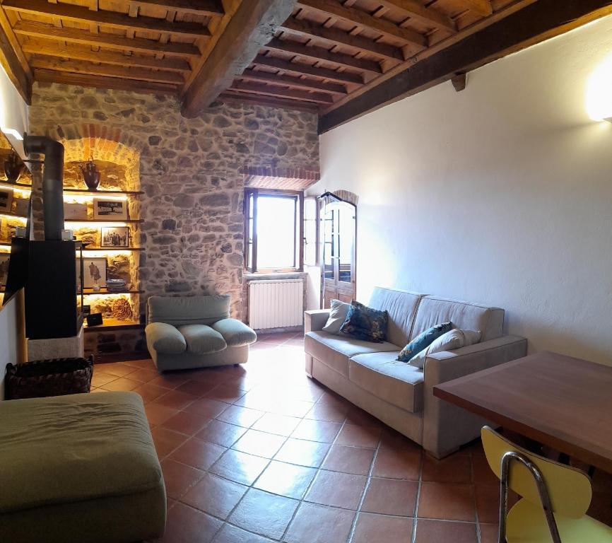 ein Wohnzimmer mit einem Sofa und einem Tisch in der Unterkunft Vivi Palagio in Chianti in Aiola