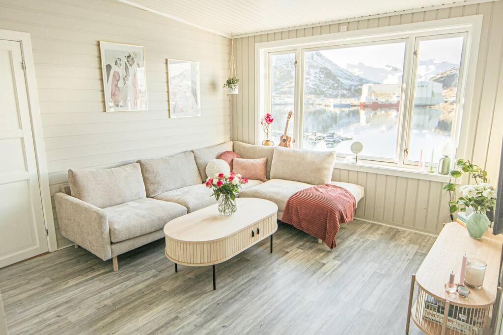uma sala de estar com um sofá e uma mesa em Koselig toppleilighet med fantastisk utsikt em Svolvær