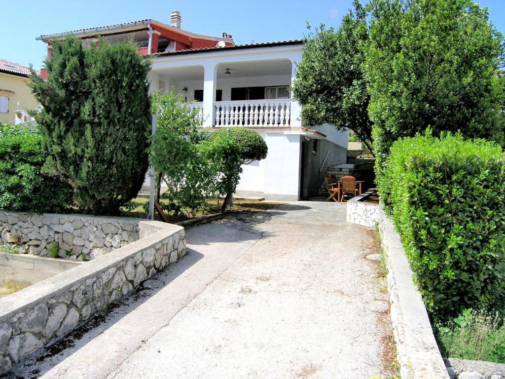 a white house with trees and a walkway at Studio Apartment Tamara in Krk