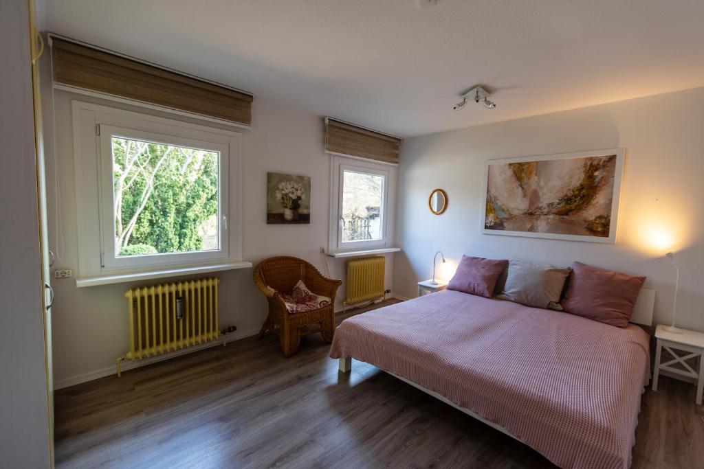 um quarto com uma cama e duas janelas em Ferienhaus - Zum Findling - em Braunlage