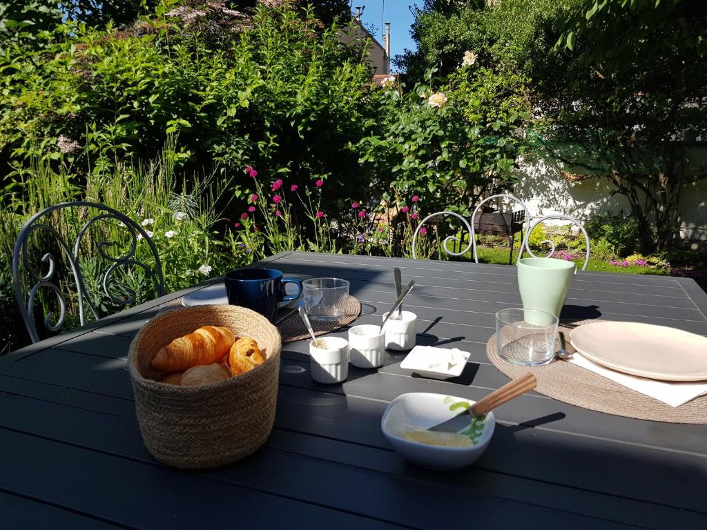 a blue table with a basket of bread on it at Peaceful green setting near to Paris Center in Pantin