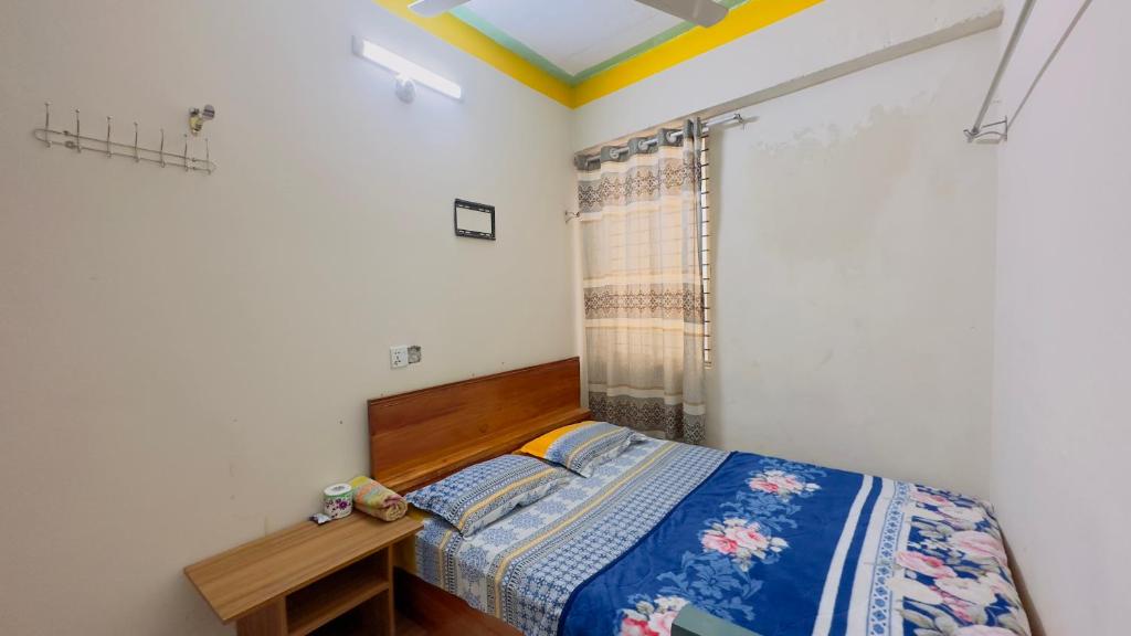 1 dormitorio con cama, mesa y ventana en Hotel Jom Jom International, en Dhaka