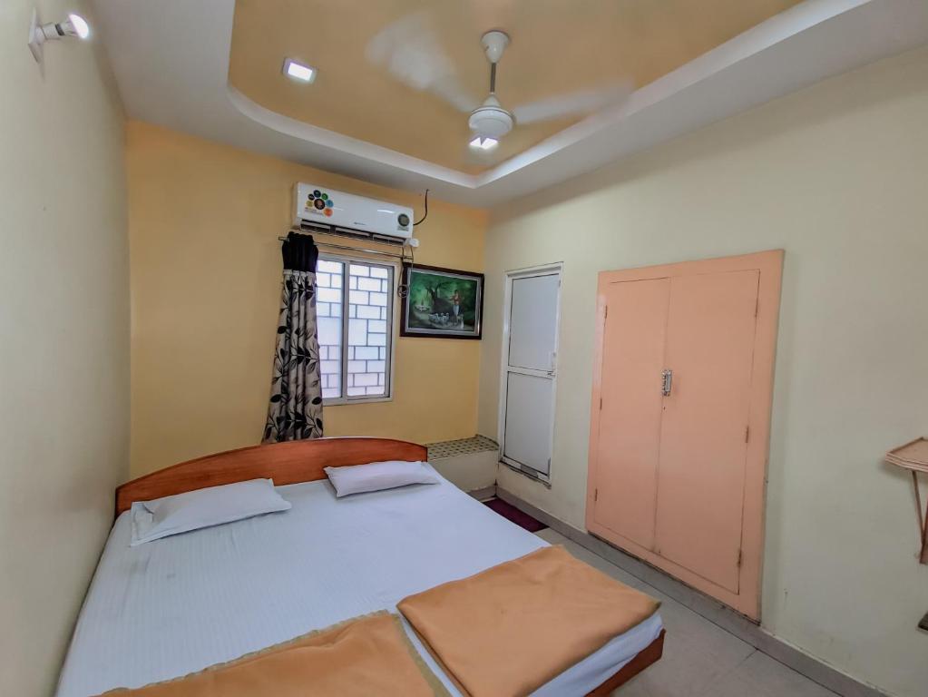 a bedroom with a large bed and a window at Hotel Annapurna in Bhuj