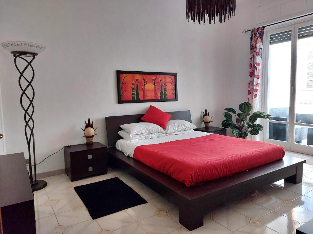 Un dormitorio con una cama grande con una manta roja. en Casa stazione centrale, en Turín