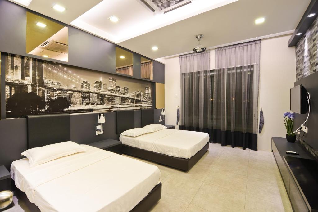 a bedroom with two beds and a tv at Parkview Homes in Ipoh