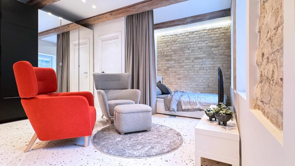 a living room with a red chair and a bedroom at Angel House Vilnius, 17 in Vilnius