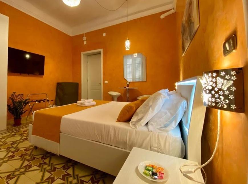 um quarto com uma cama grande e paredes cor-de-laranja em Suleima B&B Messina Centro em Messina