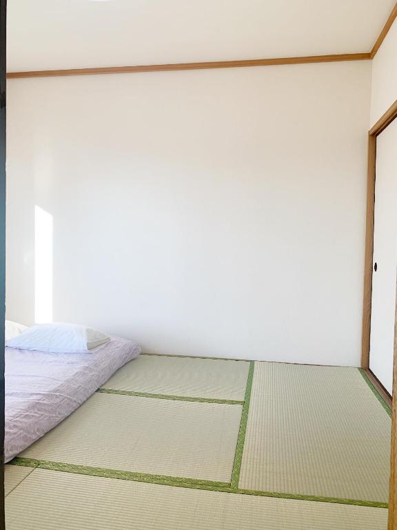 a white room with a bed and a window at 精品新装修60平米2卧室阳光公寓#干湿分离#高速无限制网路#专用电梯直达#3站直达新宿#最大7人#itk501 in Tokyo