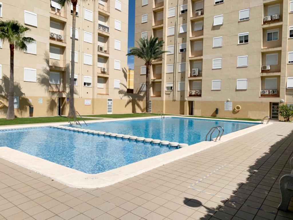una piscina frente a un edificio de apartamentos en MIAMI Playa de Gandía - Alquiler solo familias en Playa de Gandia